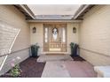 Inviting front door with glass detailing, flanked by sconces and planters, offering a warm welcome at 14033 N 39Th Ln, Phoenix, AZ 85053