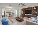 Bright and airy living room with stylish furniture, built-in shelving, and open access to the dining area at 16788 W Beth Dr, Goodyear, AZ 85338