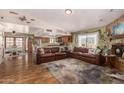 Spacious living room with hardwood floors, brick fireplace, and open layout to the kitchen at 1708 N Burbank Ct, Chandler, AZ 85225