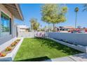 Cozy front yard featuring a seating area with artificial turf, flowers, and a block fence at 1830 N 87Th Way, Scottsdale, AZ 85257