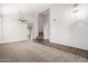 Open-concept living room area featuring vaulted ceiling, carpet, and a stairwell at 2023 S 106Th Ave, Tolleson, AZ 85353