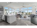 Open-concept living area with many windows, tiled floors, and seamless transition to kitchen space at 20739 W Reade Ave, Buckeye, AZ 85396