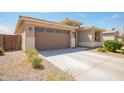 View of home with a two-car garage, concrete driveway, and low maintenance desert landscaping at 21295 E Estrella Rd, Queen Creek, AZ 85142