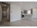 Open-concept living space flows into a kitchen featuring an island with gray cabinets and neutral tile flooring at 2570 E Music Mountain Ave, Apache Junction, AZ 85119
