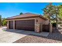 Attached two-car garage with stone accents and desert landscaping at 2890 N 156Th Dr, Goodyear, AZ 85395