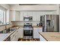 Well-lit kitchen with white cabinets, stainless steel appliances, and wooden countertops, offering style and functionality at 3116 W Folgers Rd, Phoenix, AZ 85027