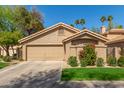 Well-maintained single-Gathering home featuring a two-car garage, a green lawn, and desert landscaping at 32 E Dawn Dr, Tempe, AZ 85284