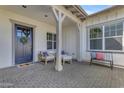 Inviting front porch with neutral furniture and a wreath on the navy blue front door at 3547 E Bloomfield Pkwy, Gilbert, AZ 85296