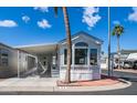 This home showcases a covered parking area, palm trees, and a well-manicured exterior at 39 Iron Ore Dr, Apache Junction, AZ 85119