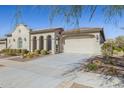 Elegant exterior view showing a spacious three-car garage and desert landscaping at 5142 N 205Th Gln, Buckeye, AZ 85396