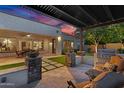 Covered patio area featuring a built-in grill, stone pillar accents, and an elegant outdoor dining area at 610 W Tonto Dr, Chandler, AZ 85248