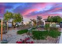 This inviting single-story home showcases a beautifully landscaped front yard, enhanced by vibrant plants and desert landscaping at 6338 E Camelot Dr, Mesa, AZ 85215