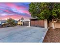 A modern single-story home boasts a wide driveway, a two-car garage, and a secluded courtyard entrance at 6338 E Camelot Dr, Mesa, AZ 85215