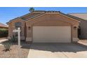 Close up of the garage door of a charming single-story home with desert landscaping at 9423 E Posada Ave, Mesa, AZ 85212