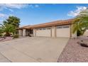 Well-maintained single-story home featuring a tile roof, multi-car garage, and desert landscaping at 9526 W Menadota Dr, Peoria, AZ 85382