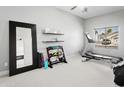 Workout room with a treadmill, exercise equipment, and a large mirror, illuminated by natural light from the window at 10721 E Pampa Ave, Mesa, AZ 85212