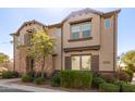 Beautiful townhome featuring a stone facade, dark brown shutters, and meticulously maintained landscaping at 1153 E Muirwood Dr, Phoenix, AZ 85048