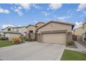 Front exterior view of a stucco home with desert landscaping and a long driveway at 1154 E Kramer Cir, Mesa, AZ 85203