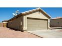 View of the two-car garage, featuring a DirectTV dish on the roof and low maintenance landscaping at 12240 W Scotts Dr, El Mirage, AZ 85335