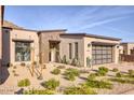 Stunning exterior view of a modern home with desert landscaping and a three car garage at 14455 N Adero Canyon Dr, Fountain Hills, AZ 85268