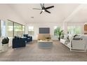 Bright living room featuring modern furniture, a ceiling fan, and large windows for ample natural light at 16510 W Baden Ave, Goodyear, AZ 85338