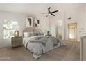 Cozy main bedroom with neutral tones, soft carpet, ceiling fan, and ensuite bathroom entrance at 16510 W Baden Ave, Goodyear, AZ 85338