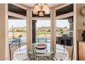 Bright breakfast nook featuring a round glass table with views of the backyard pool and golf course at 1668 E Saltsage Dr, Phoenix, AZ 85048