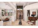 Grand foyer featuring soaring ceilings, elegant lighting, and impressive architectural details like columns and unique flooring at 1668 E Saltsage Dr, Phoenix, AZ 85048