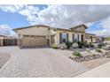 Inviting one-story home featuring desert landscape, stone detailing, and a spacious paver driveway at 20961 E Stacey Rd, Queen Creek, AZ 85142