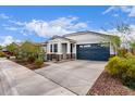 Attractive single-story home with a blue garage door, stone accents, and low-maintenance landscaping at 21105 N Blue Agave Dr, Maricopa, AZ 85138