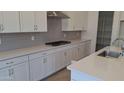 Modern kitchen featuring white cabinets, quartz countertops, subway tile backsplash, and a stainless steel range hood at 24134 N 172Nd Ave, Surprise, AZ 85387