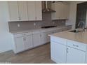 Modern kitchen featuring white cabinets, gray backsplash, stainless steel appliances, and a functional center island at 24134 N 172Nd Ave, Surprise, AZ 85387