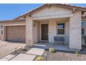 Welcoming front porch with stone accents, desert landscaping, and a cozy seating area at 26978 N 74Th Ln, Peoria, AZ 85383