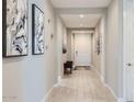 Bright hallway with wood-look tile flooring, neutral walls, and modern decor at 26978 N 74Th Ln, Peoria, AZ 85383