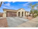 Charming single-story home featuring a two-car garage, arched entryway, and well-maintained desert landscaping at 3690 E Blue Spruce Ln, Gilbert, AZ 85298