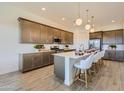 Modern kitchen with stainless steel appliances, ample counter space, and a breakfast bar with seating at 3735 E Kenley Ln, San Tan Valley, AZ 85143