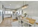 Bright dining area featuring a modern chandelier, wood floors, and an open flow into the kitchen at 4438 N 27Th St # 27, Phoenix, AZ 85016