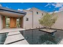 Stylish front entrance boasting a unique water feature and a modern stone walkway to the front door at 7498 E Whisper Rock Trl, Scottsdale, AZ 85266