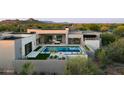 Stylish modern home boasts a luxurious pool and spa with a fire pit, perfect for outdoor relaxation and entertaining at 7498 E Whisper Rock Trl, Scottsdale, AZ 85266