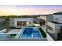 Expansive view of a modern backyard with a sparkling pool, spa, fire pit, and outdoor kitchen against a mountain backdrop at 7498 E Whisper Rock Trl, Scottsdale, AZ 85266