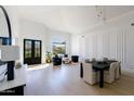 Spacious living area with a vaulted ceiling, modern decor, and a view of the outside through large windows at 9238 E Palm Tree Dr, Scottsdale, AZ 85255