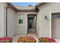 Inviting front entrance with manicured flower beds, an arched entryway, and a dark wood front door at 9738 E Tiburon Ave, Mesa, AZ 85212