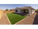 Backyard featuring low-maintenance turf, gravel landscaping, and a covered patio at 9838 E Research Ave, Mesa, AZ 85212