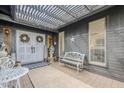 Charming entrance featuring a double door, overhead trellis with lights, and decorative bench and table at 1035 W 2Nd St, Mesa, AZ 85201