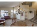 Inviting living room featuring vaulted ceilings, a large chandelier, comfortable couches, and ample natural light at 14406 N 129Th Ave, El Mirage, AZ 85335