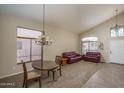 Bright living room featuring high ceilings, large windows, modern chandelier, and plush leather couches at 14406 N 129Th Ave, El Mirage, AZ 85335