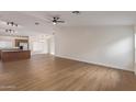 Open-concept living room featuring wood-look flooring, neutral paint, and seamlessly connects to the kitchen and dining area at 14838 N 172Nd Ln, Surprise, AZ 85388