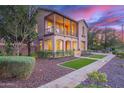 Charming two-story home featuring a front porch, balcony, and landscaped front yard at twilight at 15289 W Valentine St, Surprise, AZ 85379