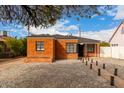 Lovely brick house with dark windows and roof, complemented by a low maintenance front yard at 1810 N 12Th St, Phoenix, AZ 85006