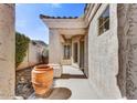 Inviting front porch with a textured stucco wall and a large decorative terracotta pot, creating a warm, sunlit entryway at 26560 N 115Th St, Scottsdale, AZ 85255